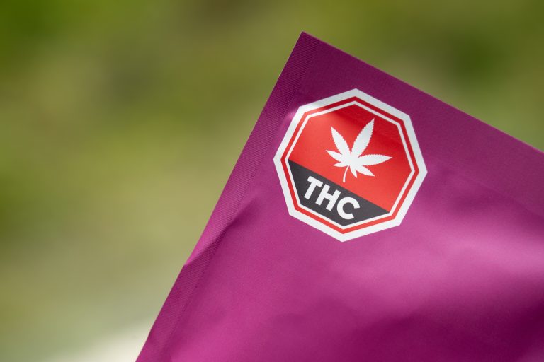 Close-up of cannabis packaging with a THC warning label emphasizing safety and regulatory compliance