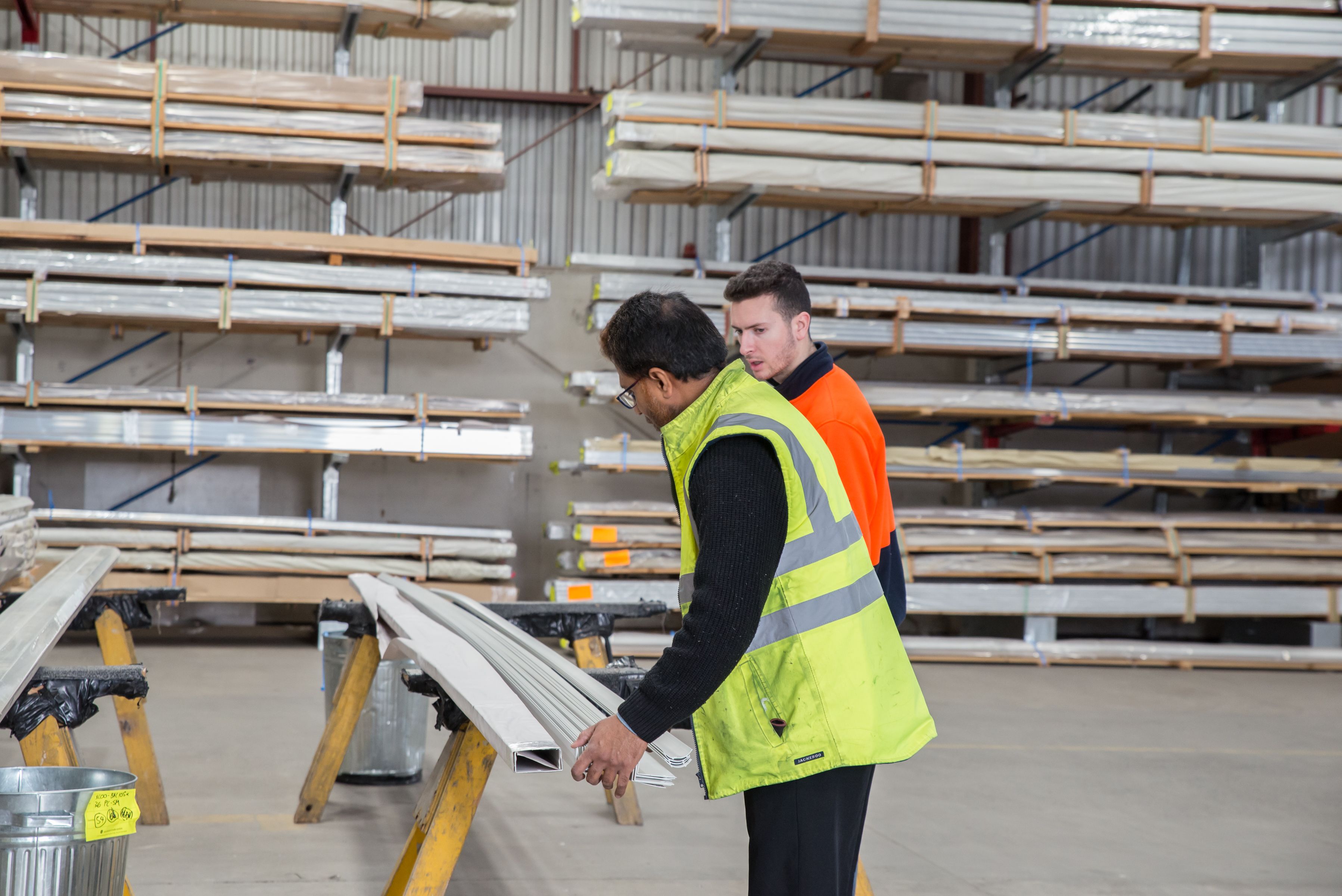 Two workers inspecting materials in a warehouse, focusing on packaging quality control